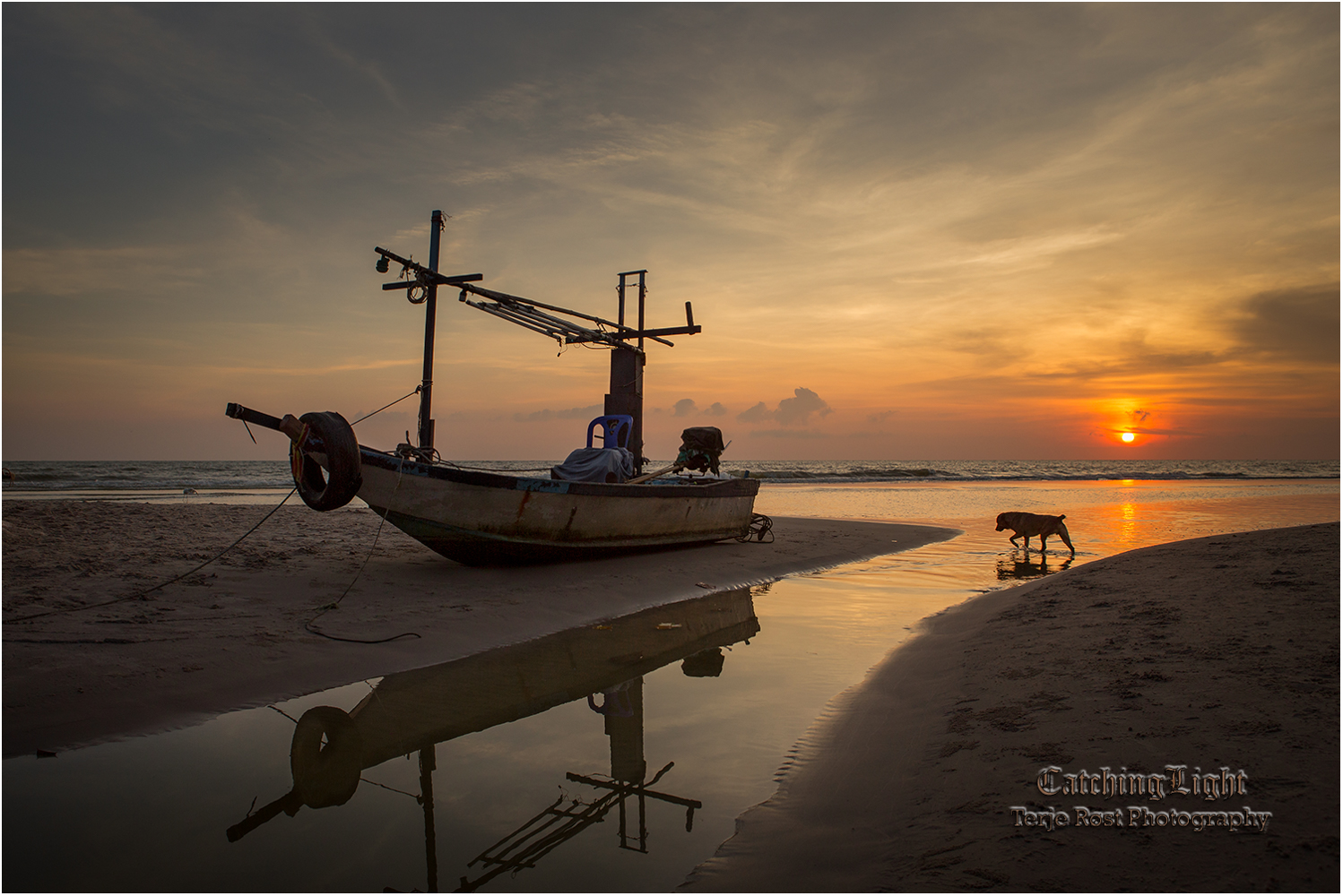 Sunrise over dog and stranded boat